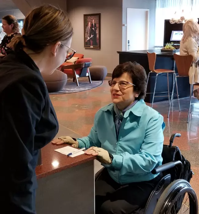 Rosemarie Rossetti asking a question of hotel lobby guest services representative